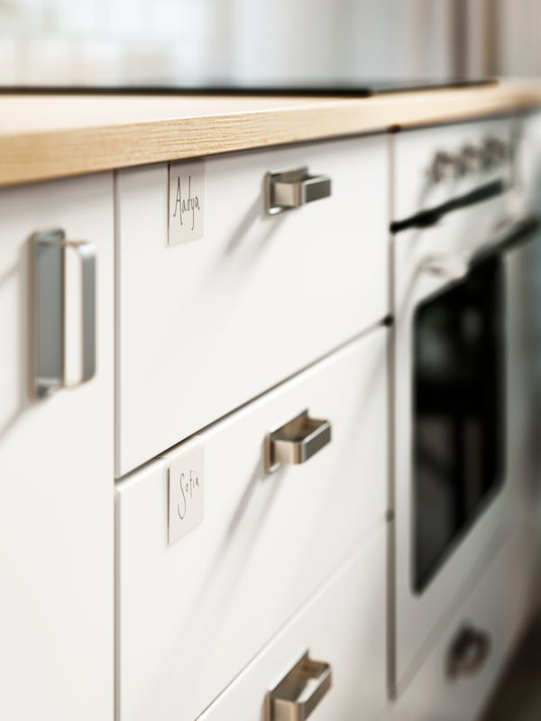 A section of an EKBACKEN ash-effect laminate worktop and a combination of white METOD base cabinets beneath.