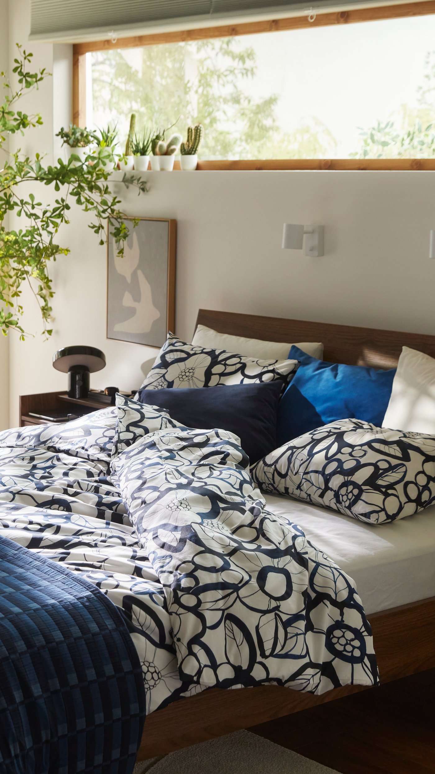 A dark blue SANELA cushion cover in the bedroom