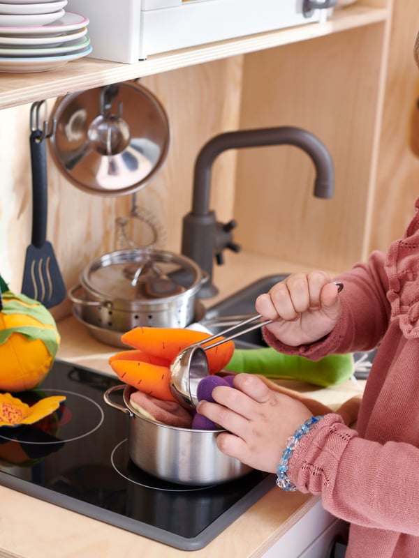 Juguetes de peluche de comida DUTKIG sobre una cocinita de juguete para niños