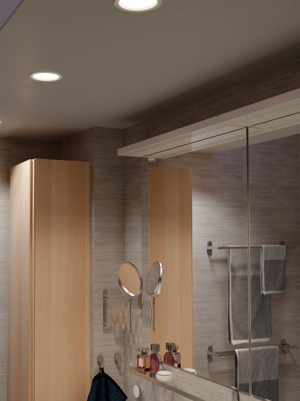 Bathroom ceiling with three LED recessed spotlights that are dimmable, a TRÅDFRI remote is mounted on the wall below.