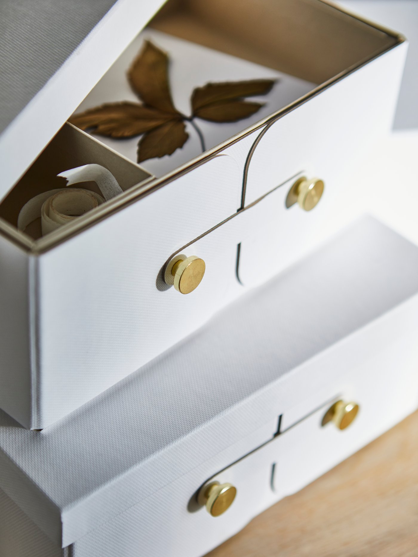 Two white storage containers are stacked on top of each other, the top one is opened.
