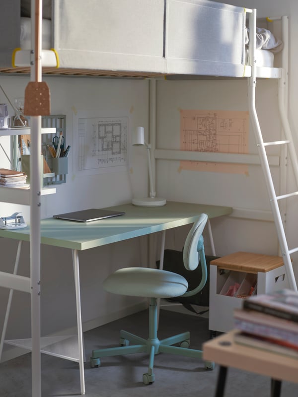 A BLECKBERGET swivel chair and LAGKAPTEN/TILLSLAG desk sit under a VITVAL loft bed. A lamp and laptop are on the desk.