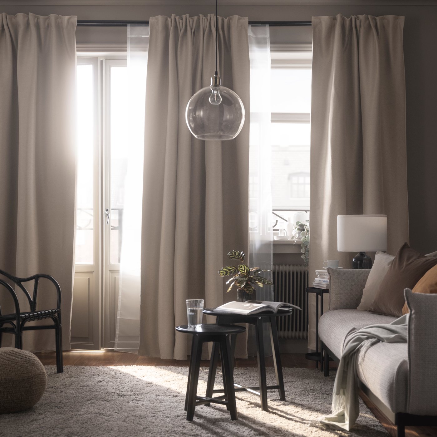 Une paire de rideaux assombrissants VILBORG beige avec ruban fronceur dans le salon