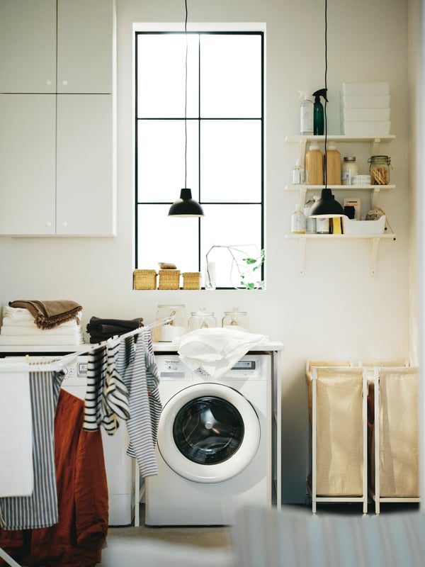A home laundry with a white ENHET storage combination for laundry and two white ENHET laundry bags with castors.