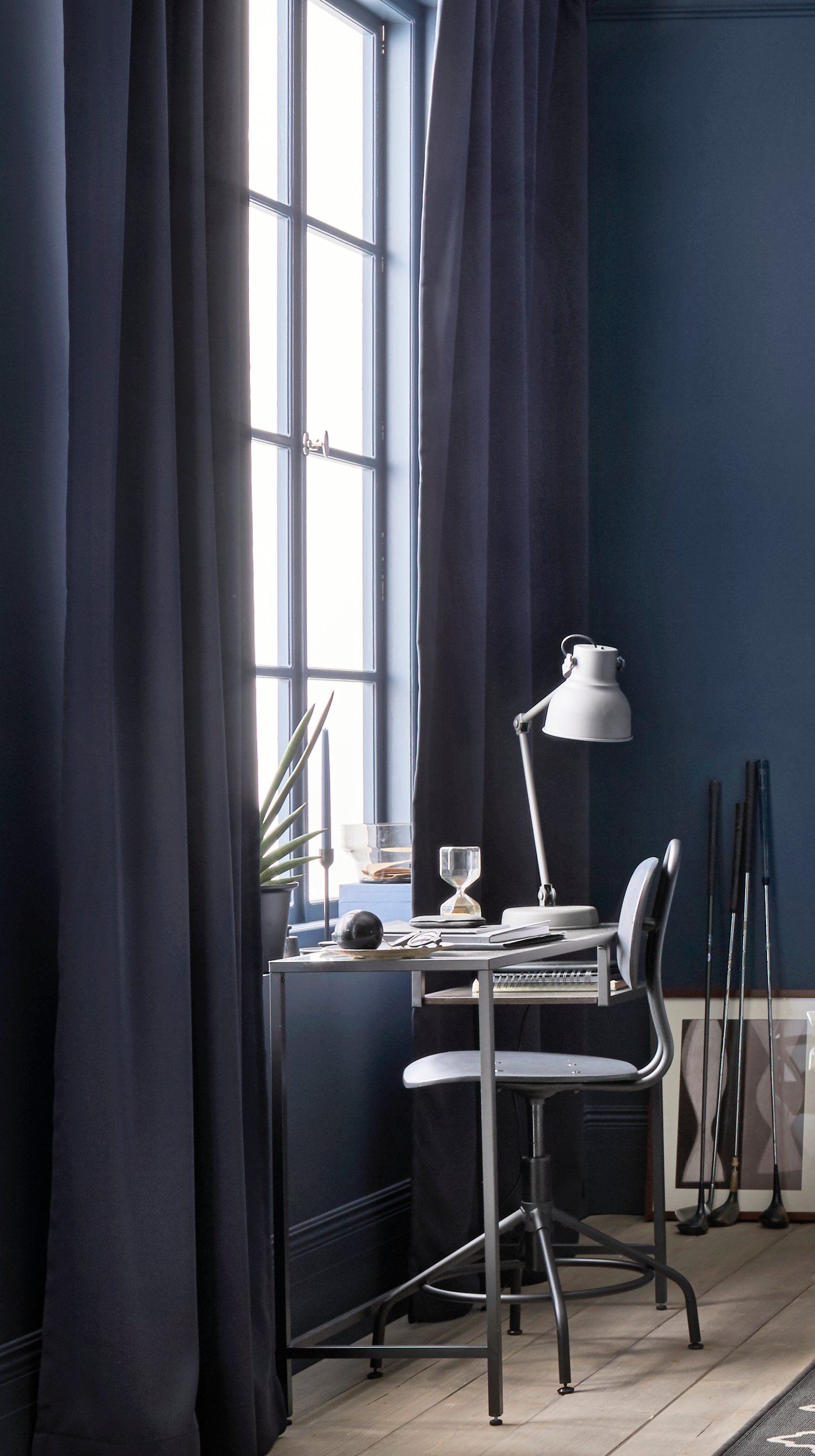 A grey VITTSJÖ desk in font of a window in a room with dark blinds