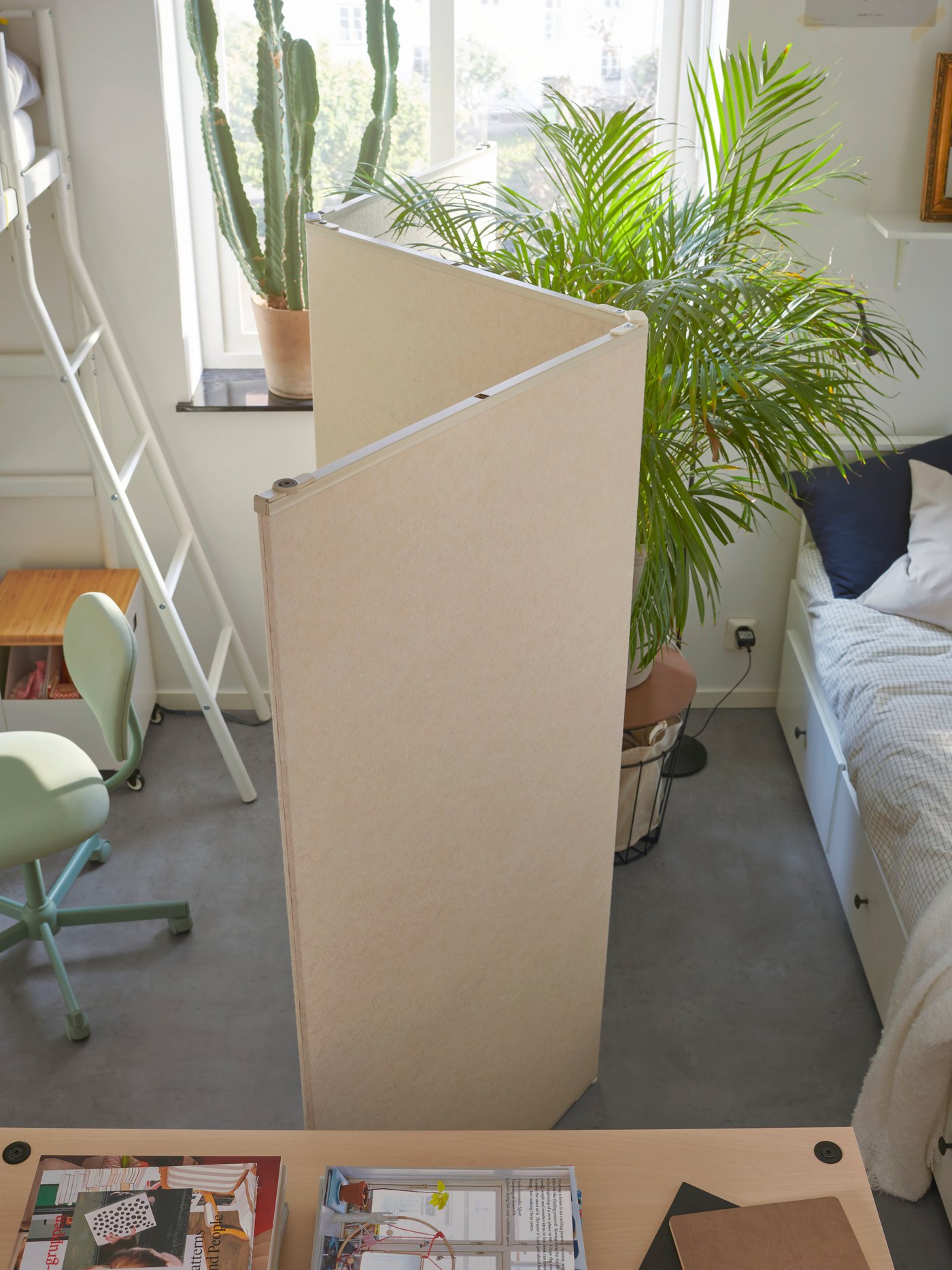 A VARHAUG room divider zig-zags down the middle of a shared dorm room, with separate sleeping areas.
