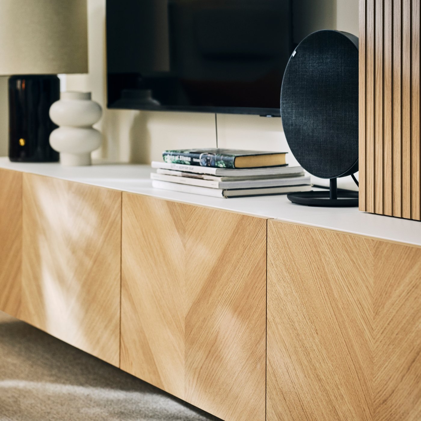 本や装飾品、SOLSKYDD/ソルシッド Bluetoothスピーカーが置いてあるBESTÅ/ベストー メディア収納コンビネーション。