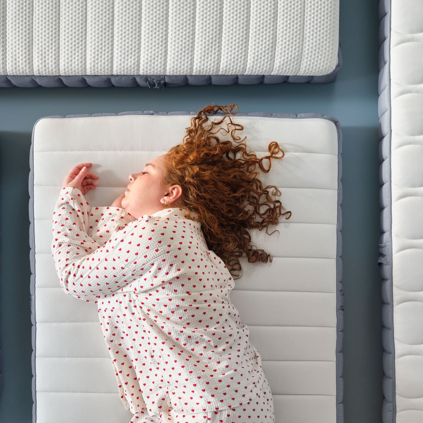 Un matelas à ressorts ensachés VALEVÅG ferme/bleu clair dans une chambre.