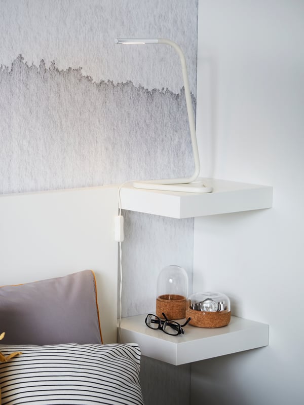 A small wall-mounted LACK wall shelf next to a bed
