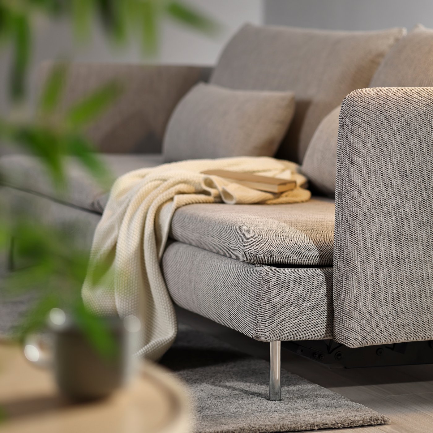 Närbild på SÖDERHAMN bäddsoffa i beige med naturvit filt. 