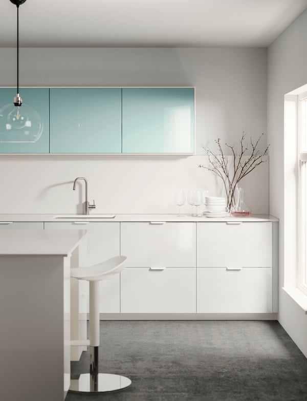 Kitchen worktop with sink, hob and utensils framed above and below with rows of white-front METOD cabinets.