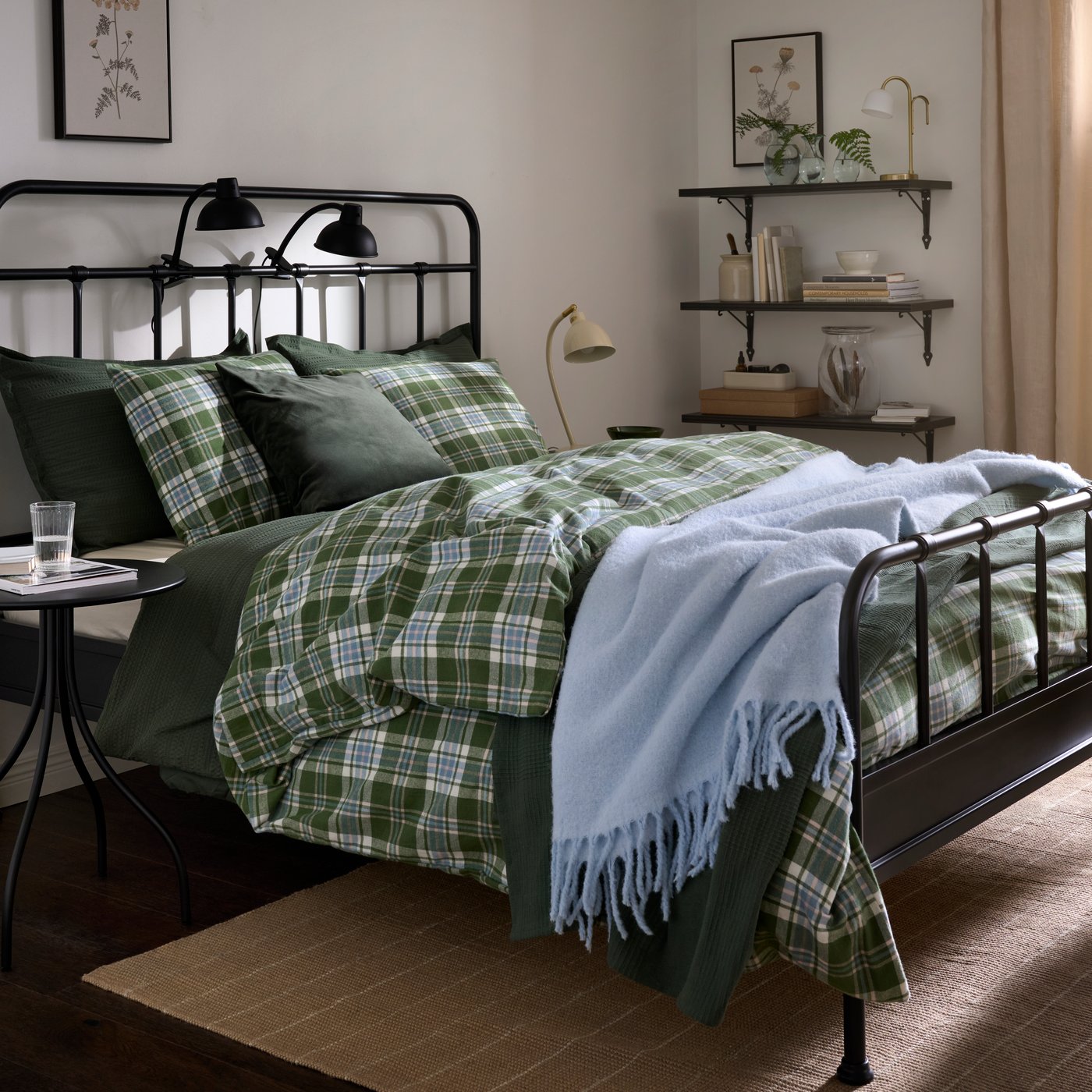 A bedroom with STJÄRNÖ bed featuring green flannel BANBJÖRNBÄR duvet cover and a light blue blanket.