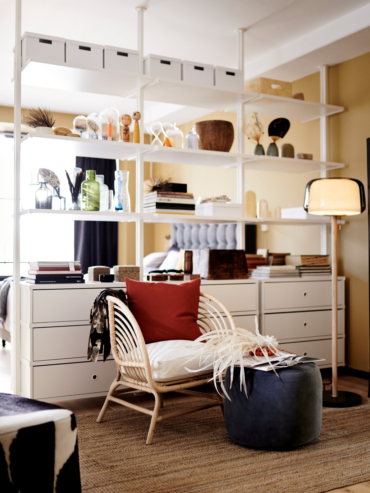 An ELVARLI wardrobe combination stands in a blue room holding clothes hanging on a rail, bags and other items.