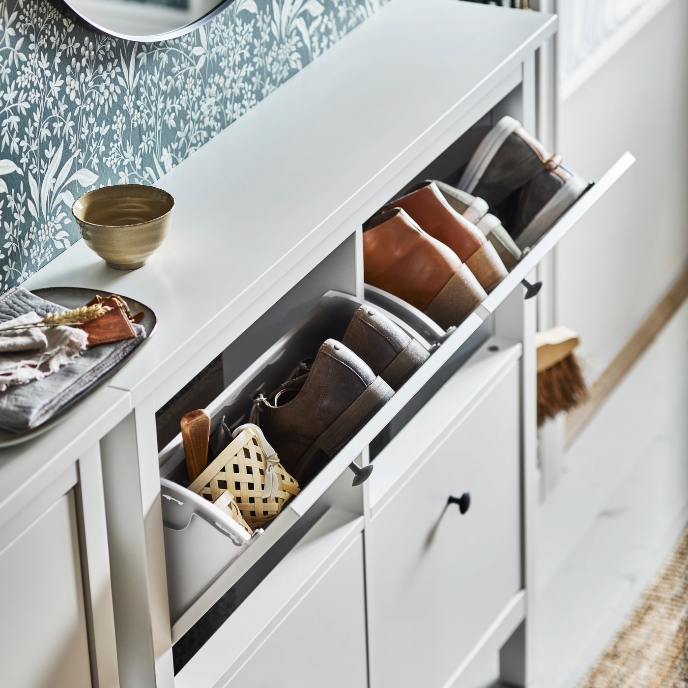 Two white HEMNES shoe cabinets with 4 compartments against a green wall with two compartments open showing pairs of shoes.