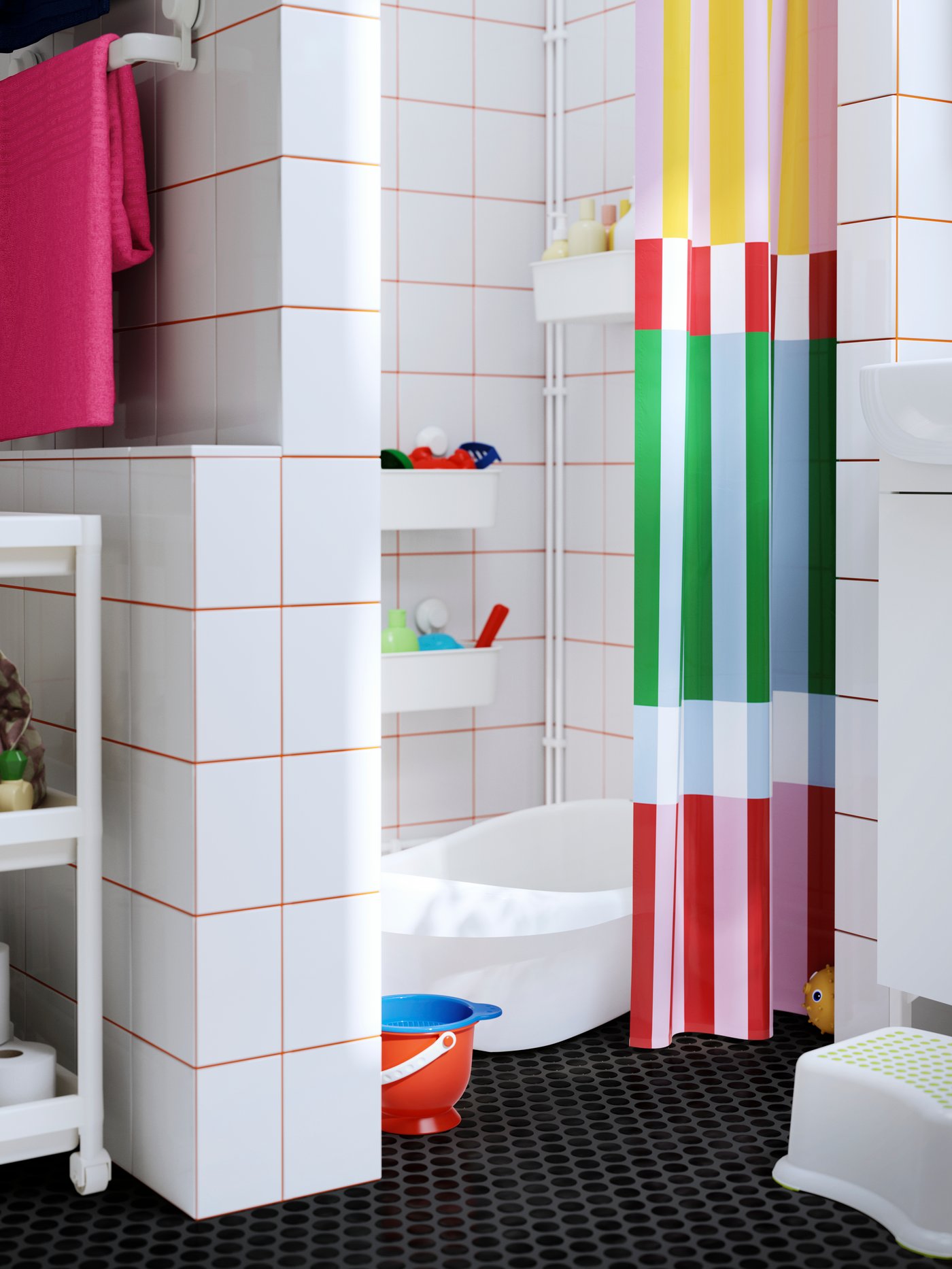A bathroom with a colourful shower curtain, a baby bath, and a TISKEN basket with suction cup holding plastic toys.