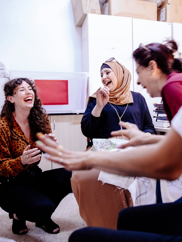 IKEA zaposleni i zanatlije iz društvenog preduzeća Jordan River Foundation uživaju u smehu na dizajnerskoj radionici.