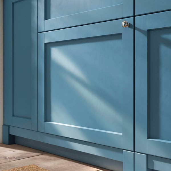 A closeup of SEKTION cabinets with legs and plinths in matching LERHYTTAN blue, offering a crafted and built-in kitchen look.