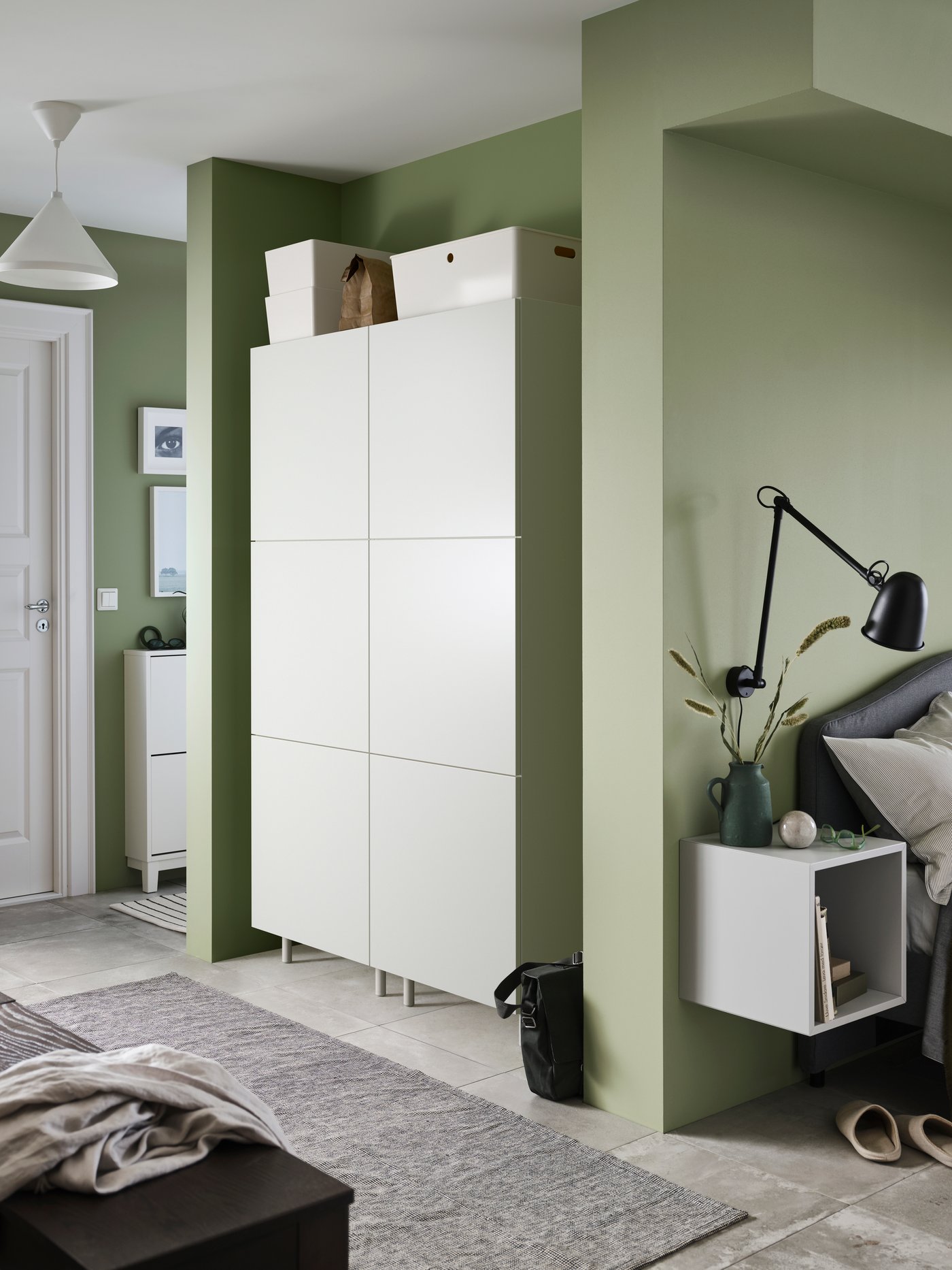 A PLATSA wardrobe with some white KUGGIS boxes with lids on top stands in a green hallway with a TIPHEDE black/natural rug.