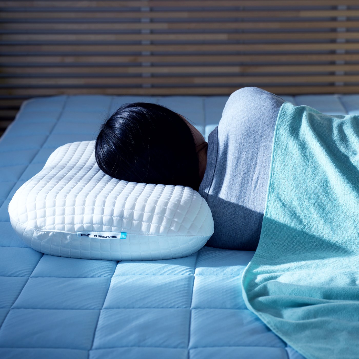 A beige/blue KEJSAROLVON mattress protector in the bedroom