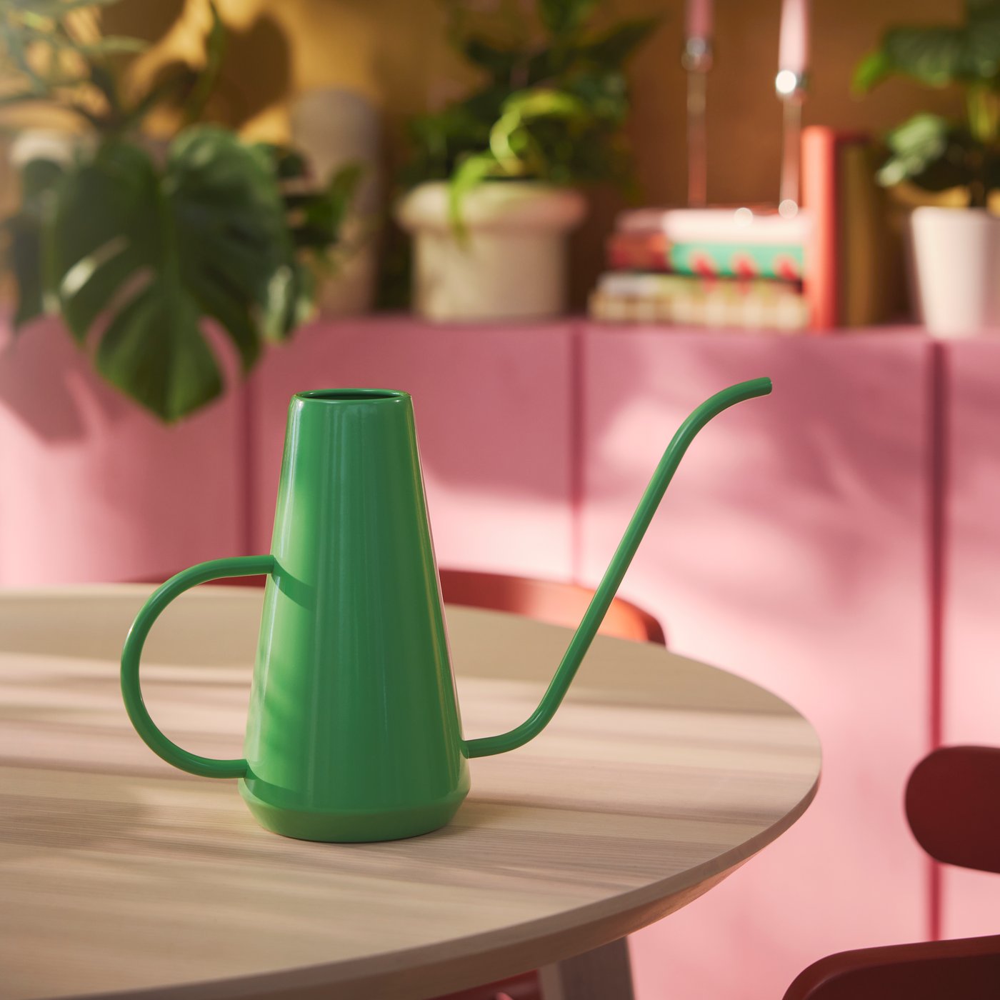 A bright green DOFTRIPS watering can on a round table in a colourful room. The can’s narrow spout is perfect for small shoots.