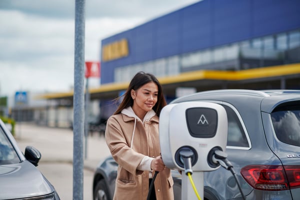 A woman charging her car at an IKEA store.