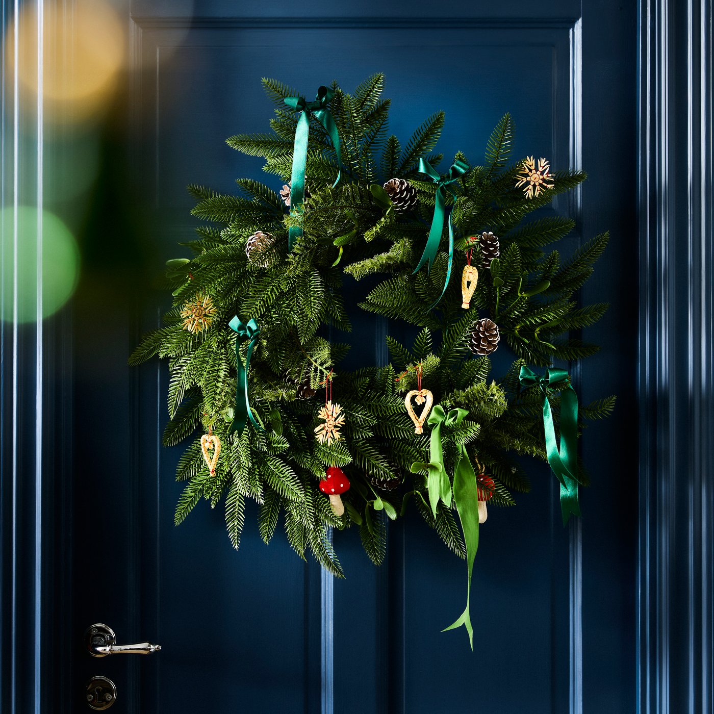 An in/outdoor/pine cone green VINTERFINT artificial wreath in the hallway
