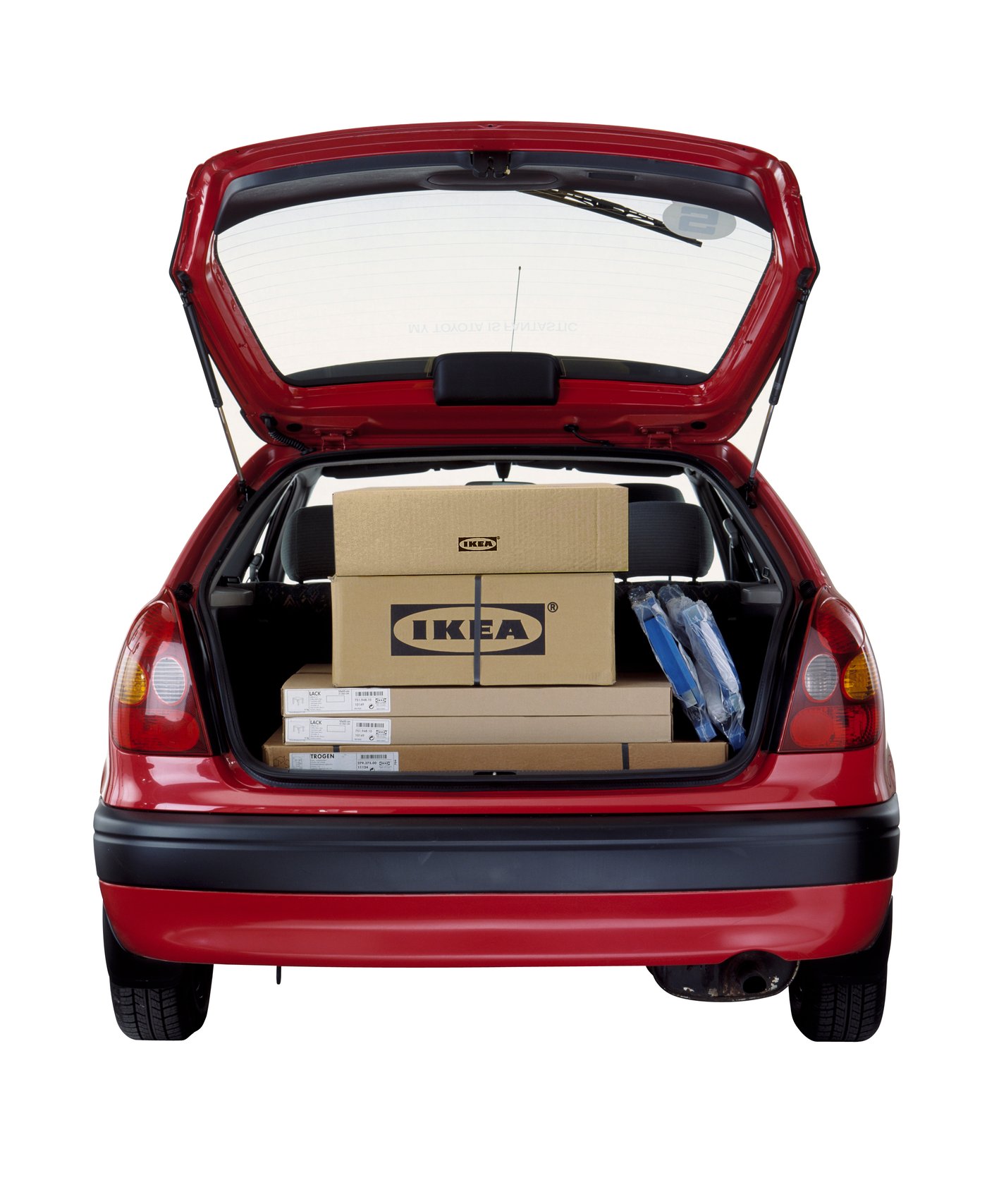 赤い車のトランクに荷物が載っている。