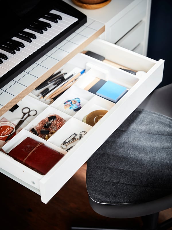 KUGGIS umetak s osam pregrada ispunjen dodacima za pisaći sto u otvorenoj fioci MICKE pisaćeg stola bele boje/boje antracita.