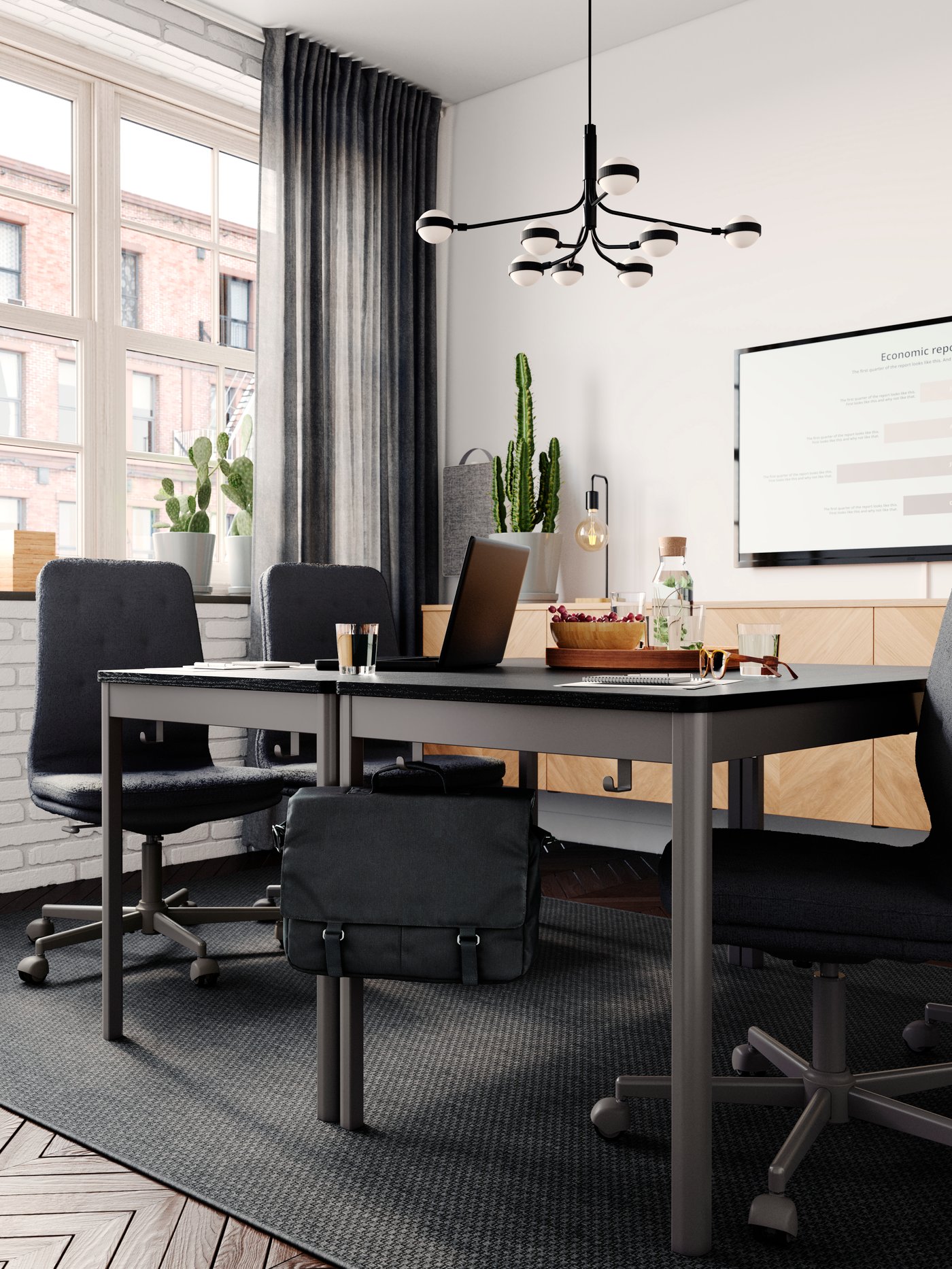Mötesrum inrett med IDÅSEN svarta konferensbord med svarta stolar framför vit vägg med en stor tv.