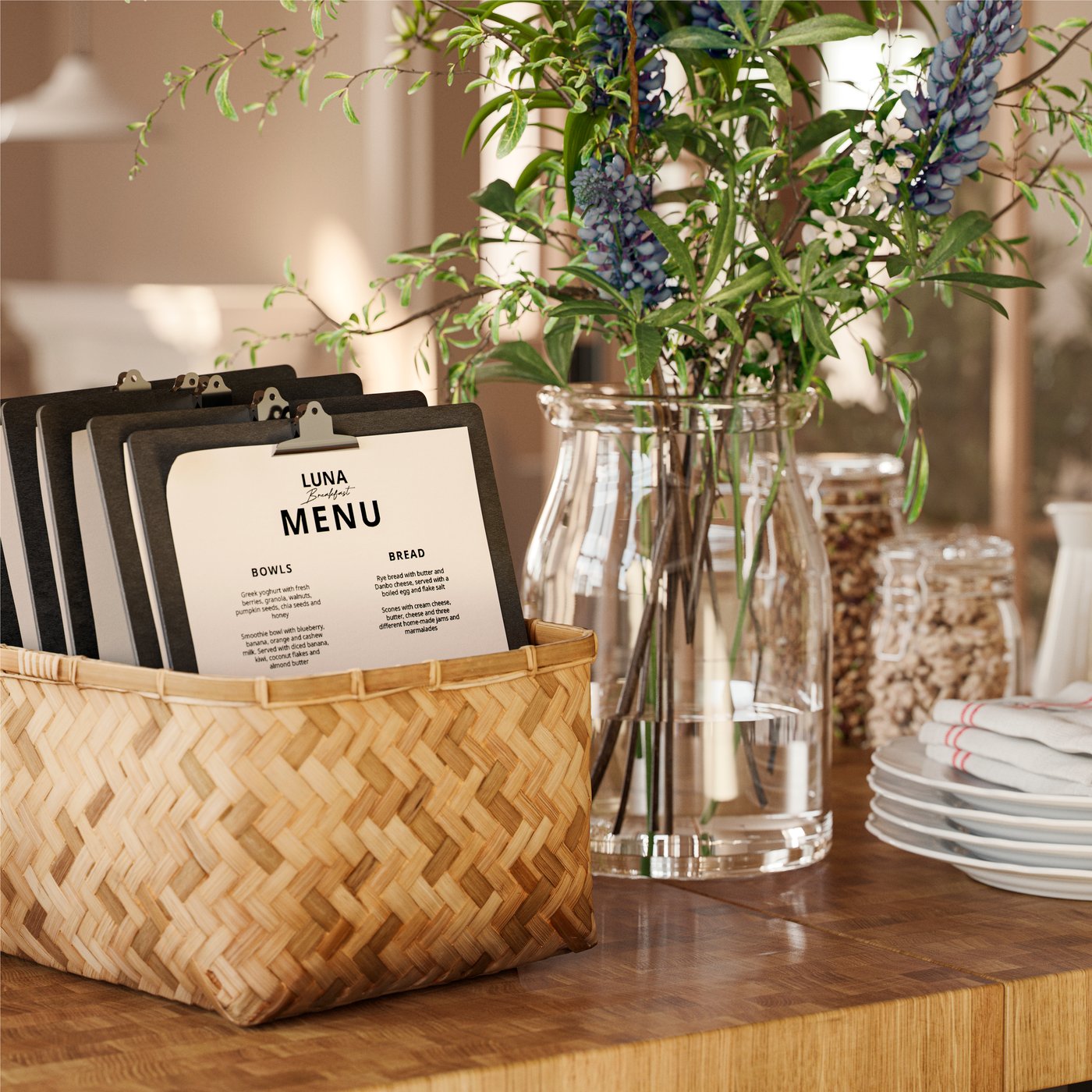 A woven bamboo MJÖLKKANNA basket holds clipboards and menus on a table by a vase of flowers and a stack of plates.