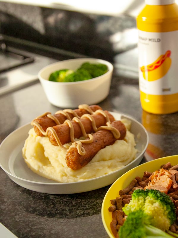 A plate of mashed potatoes and hot dogs.