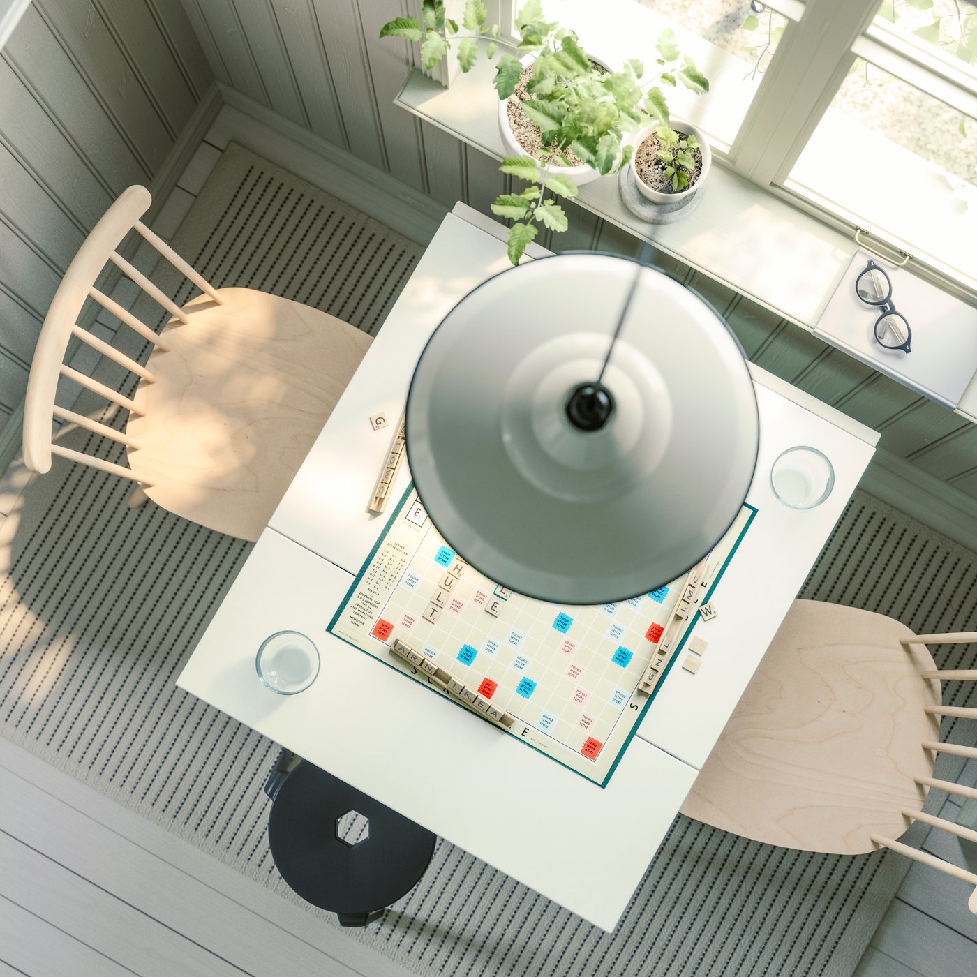 An eagle-eye’s view of a HAUGA drop-leaf table in white and birch veneer, with HÖGVED chairs, placed next to a window.