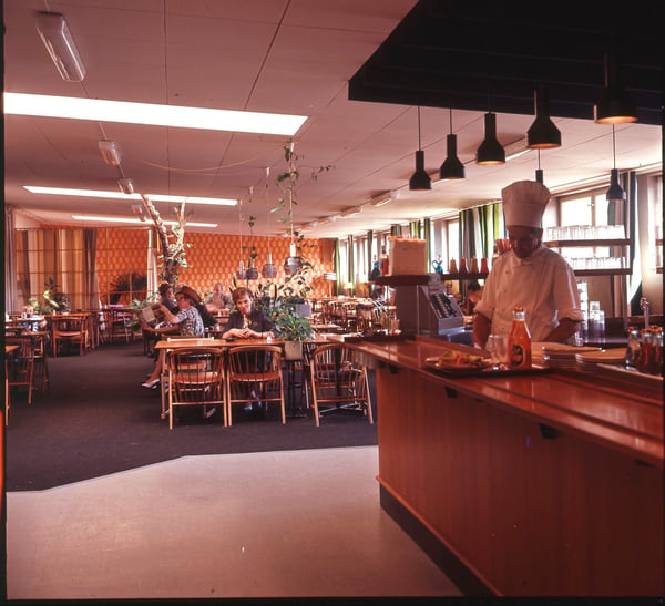 Kuvar s kuvarskom kapom iza pulta u IKEA restoranu negde tokom 1960-ih.