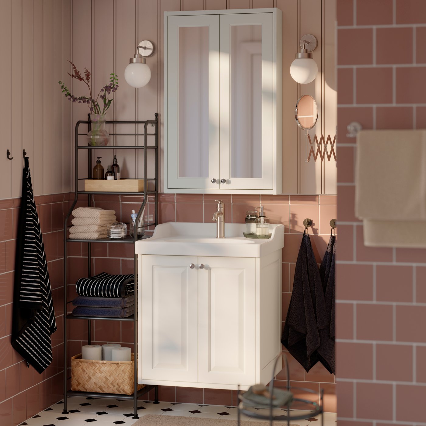 A bathroom with a white TÄNNFORSEN vanity unit, featuring two drawers and a washbasin, next to a metal shelf with towels.