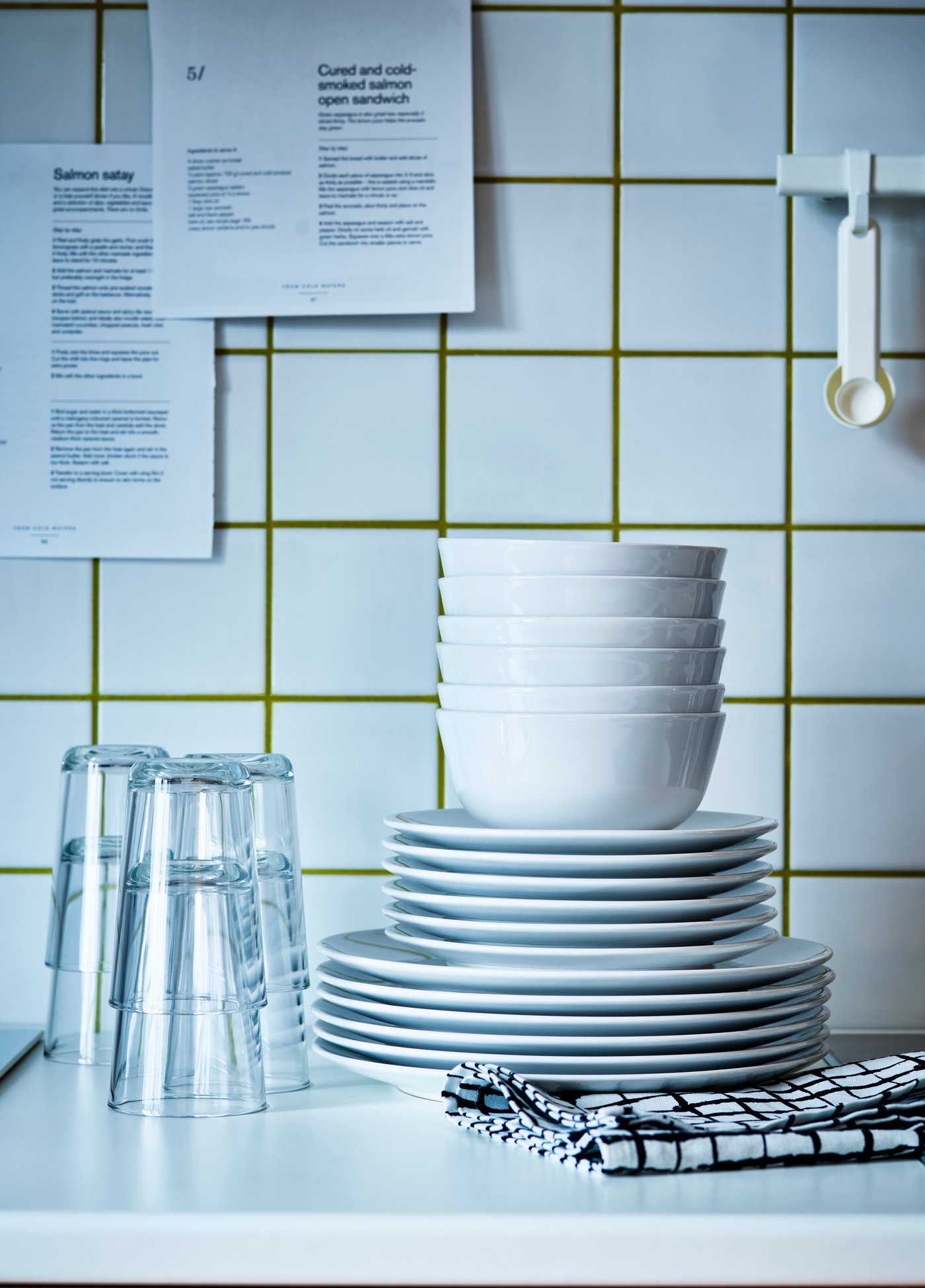 Une section de la table a été décorée pour les Fêtes, avec des assiettes OFTAST blanches, des verres à vin POKAL et des couverts UPPHÖJD beiges.