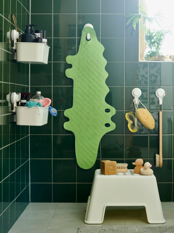 El interior de una ducha con canastos con ventosas TISKEN, un butaco para niños y un piso para evitar que se resbalen.
