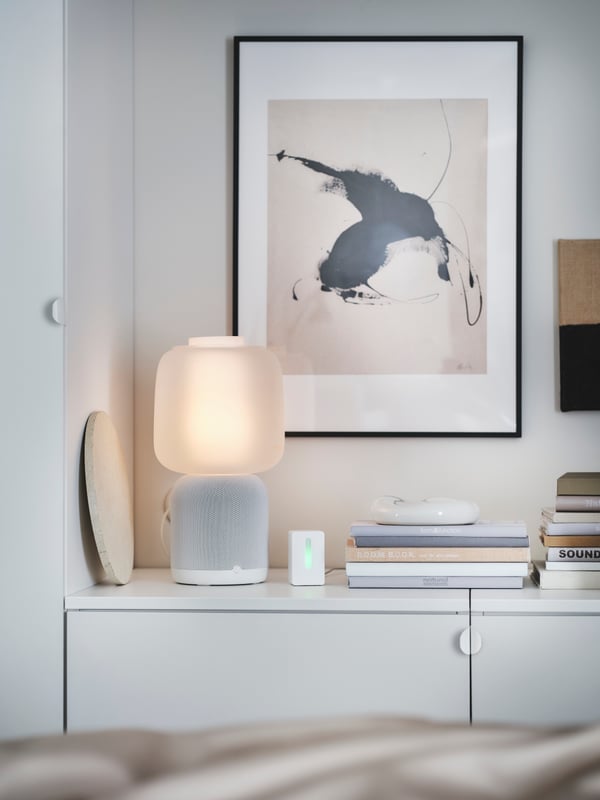 Mehrere erdfarbene Dekorationen, u. a. mit einer SYMFONISK Tischleuchte mit WiFi-Speaker in Weiß.