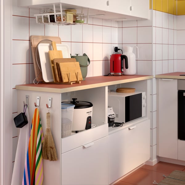 VEDDINGE drawer fronts and doors on kitchen storage with EKBACKEN worktops and a PÅLYCKE clip-on basket hanging above.