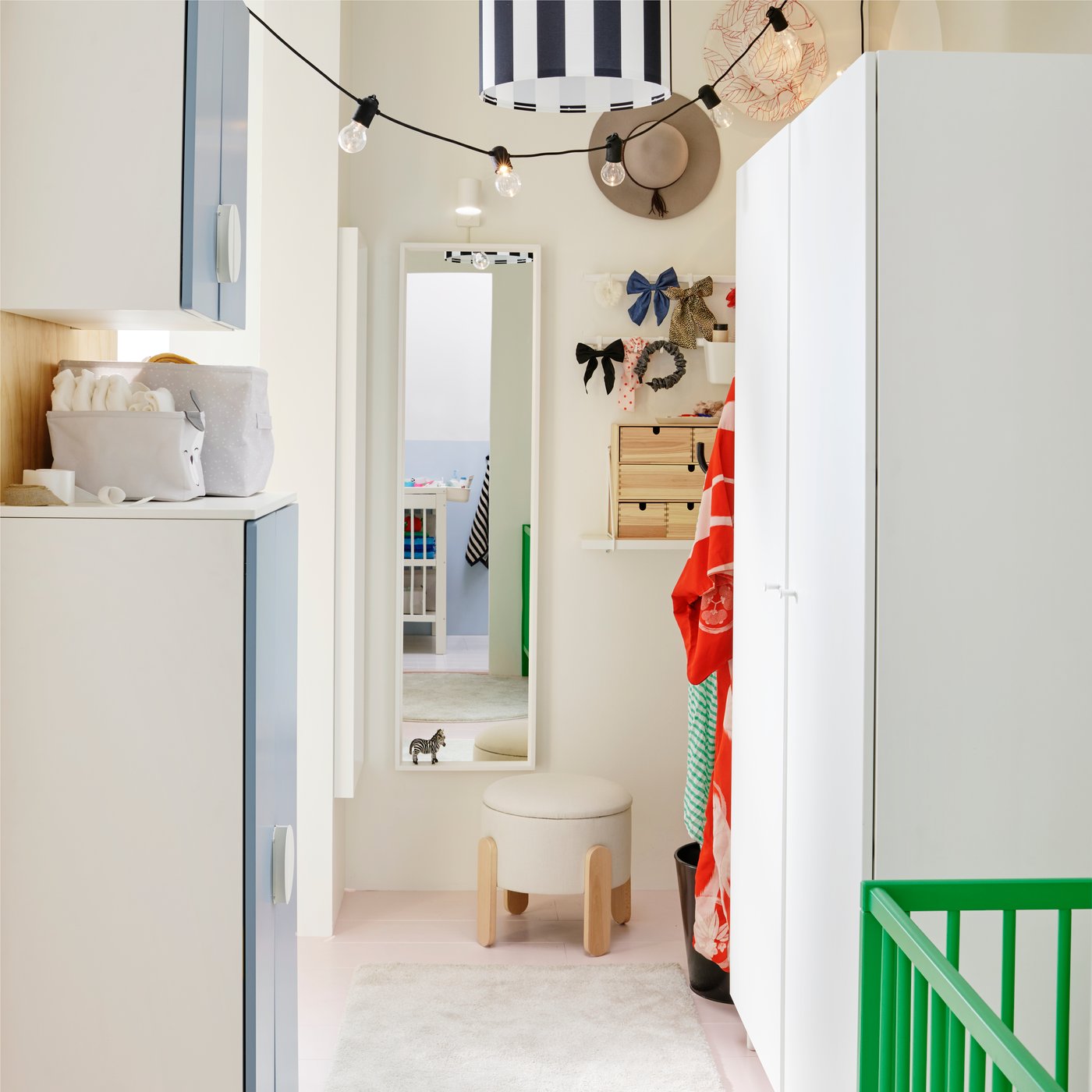 A dressing area with a white PLATSA wardrobe on one side and a NISSEDAL mirror on the wall at one end with a stool in front.