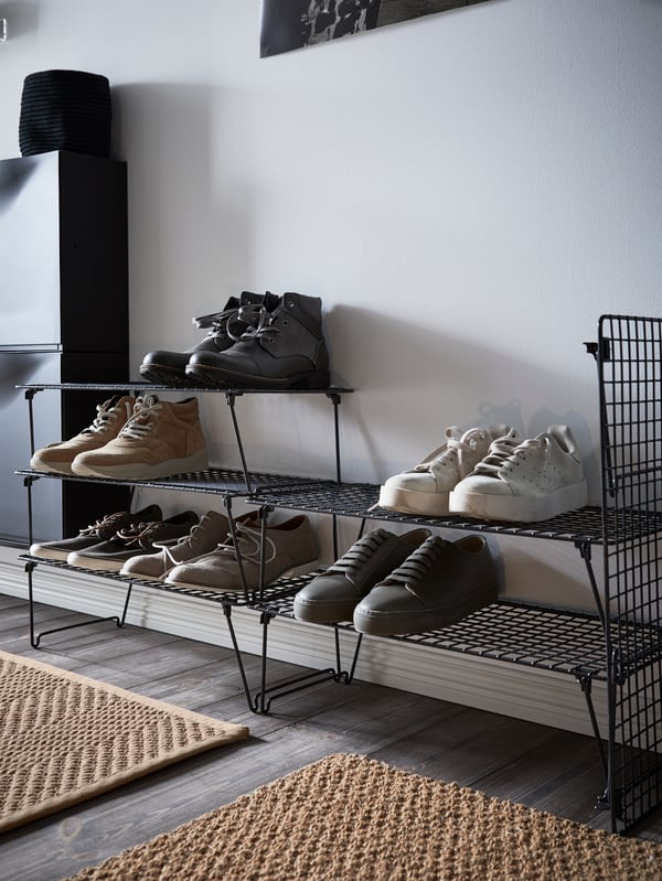 Teil eines Kleiderschranks, in dem eine GREJIG Schuhaufbewahrung mit Schuhen zu sehen ist.