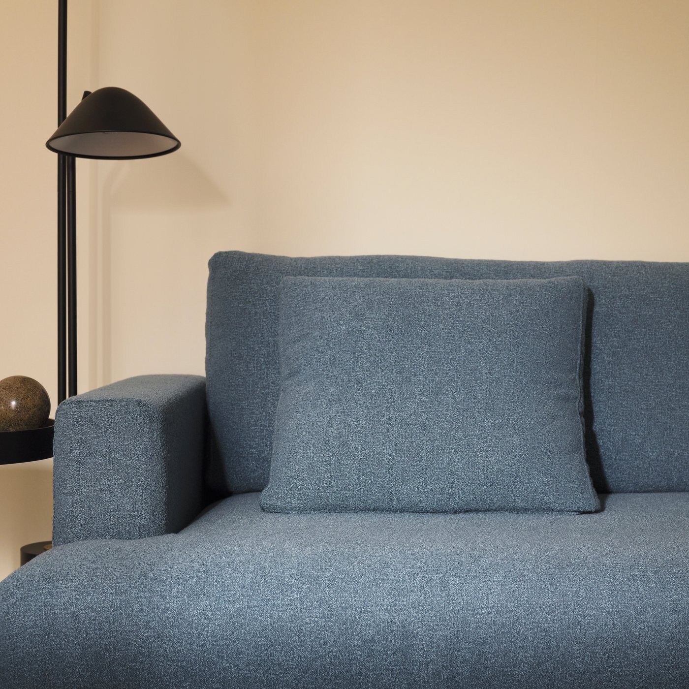 A black TRÅDNATE floor uplighter/reading lamp stands beside a dark grey-blue UPPÅKRA 4.5-seat modular sofa.