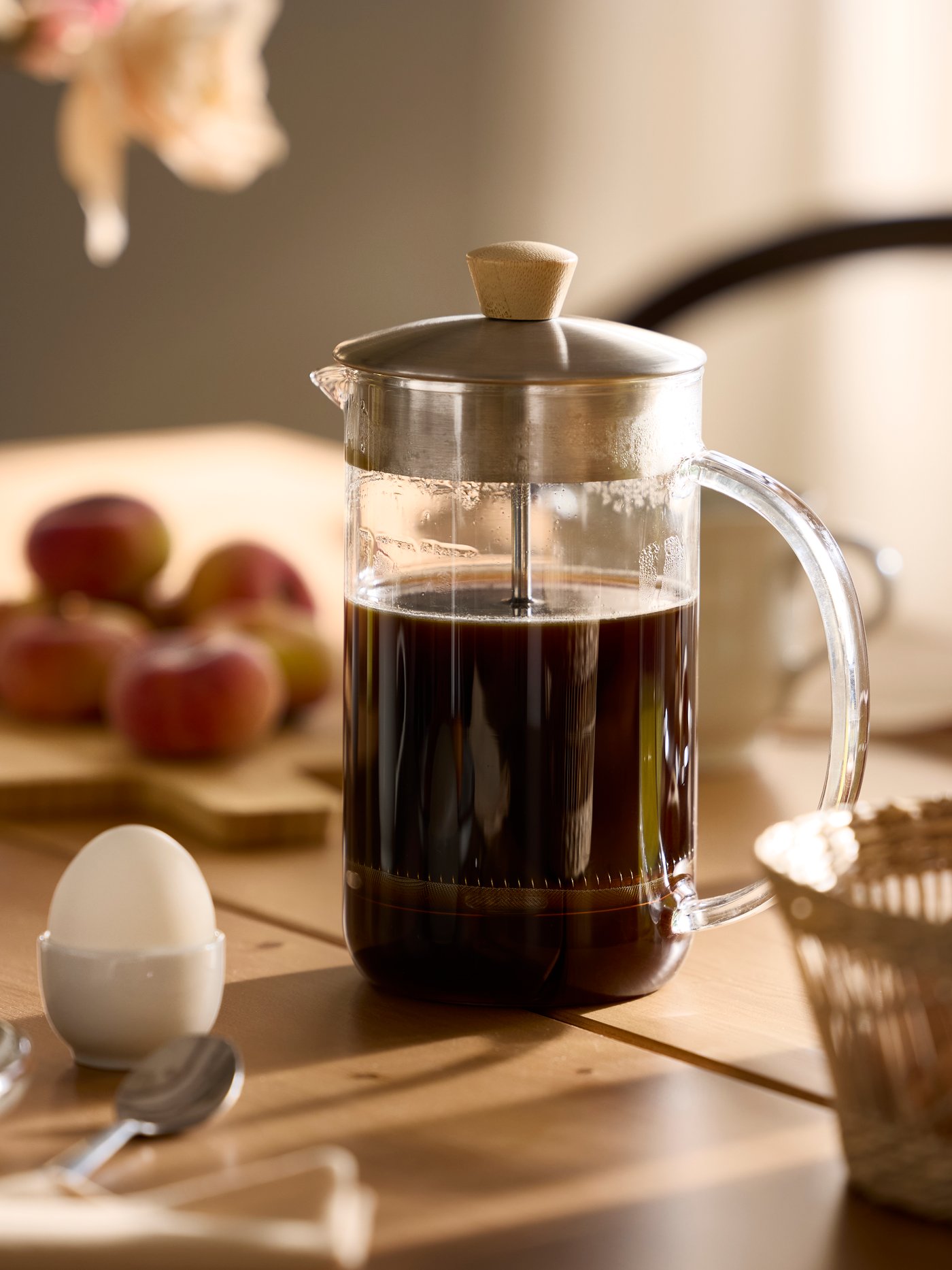 Close-up of IKEA 365+ coffee/tea maker full of coffee, set on a table with morning light shining from the side.