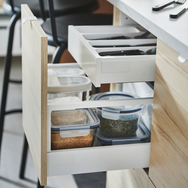 In einer Küchenschublade stehen frischhalteboxen drinnen von der IKEA 365 plus Serie und darüber eine Lade mit Besteck.