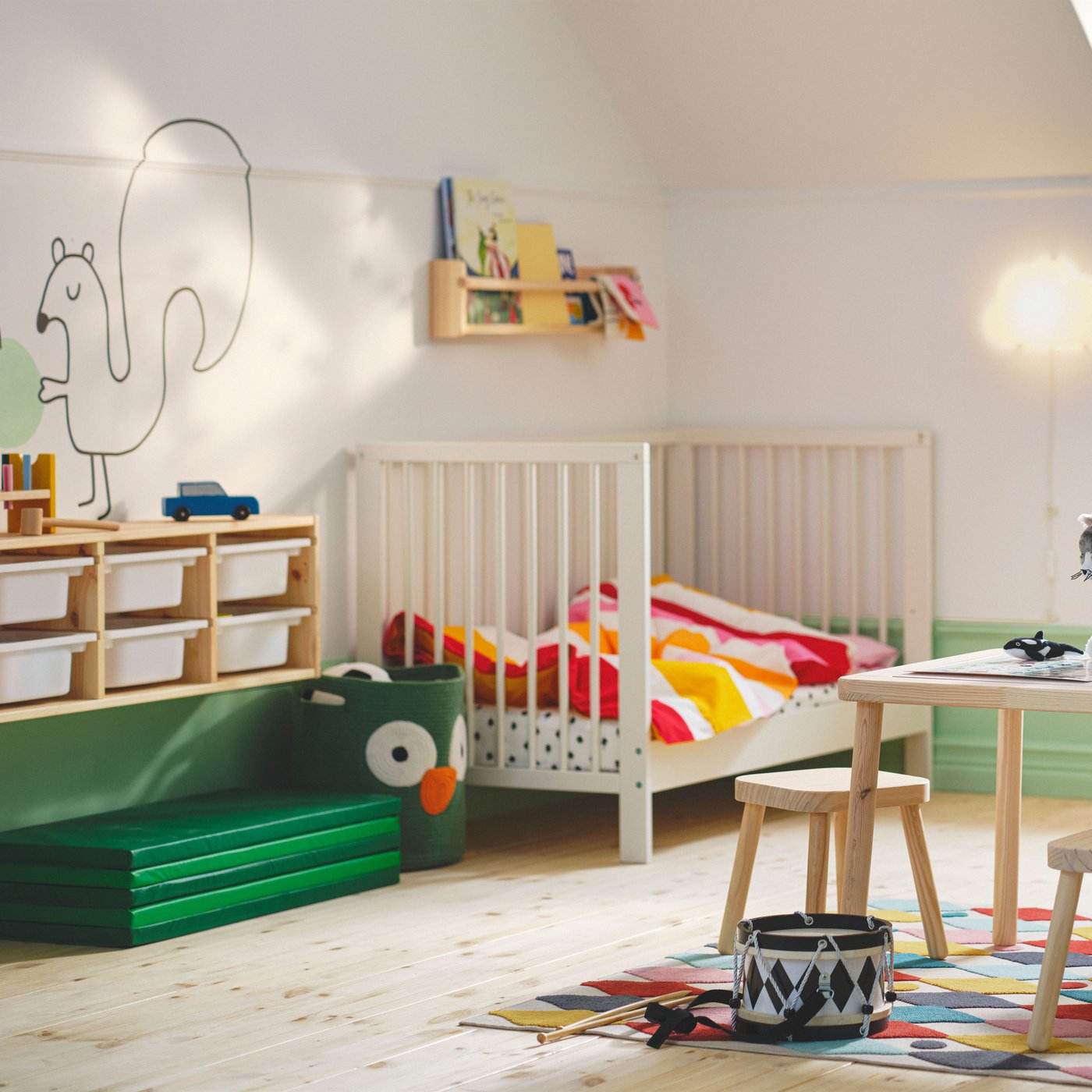 A green PLUFSIG folding gym mat in the childrens room