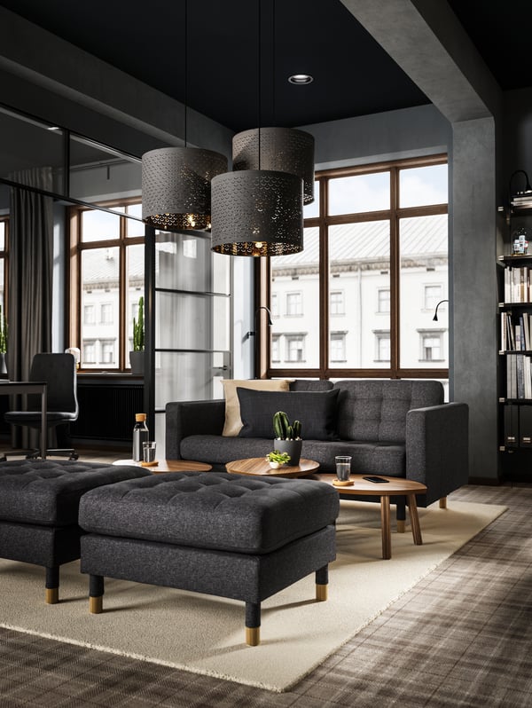 Ein dunkles Wohnzimmer mit einem LANDSKRONA Sofa und Sofaelementen.