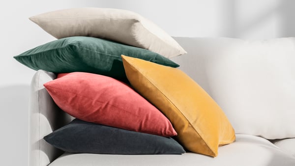 A dark green SANELA cushion cover