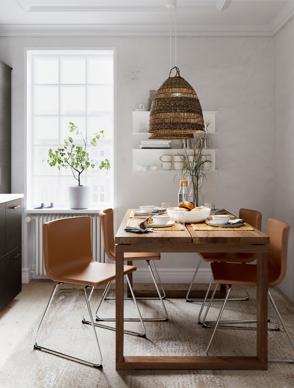 Lámpara TORARED en un comedor iluminado, junto a una mesa MÖRBYLÄNGA de madera y sillas BERNHARD.