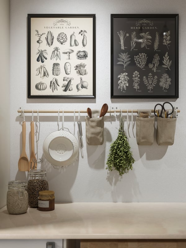 Two KNOPPÄNG posters and NEREBY birch rails with hanging kitchen utensils and containers over a KASKER worktop.