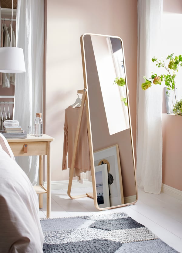 A white JÄRA lampshade in the bedroom and IKORNNES standing mirror in Singapore bedroom