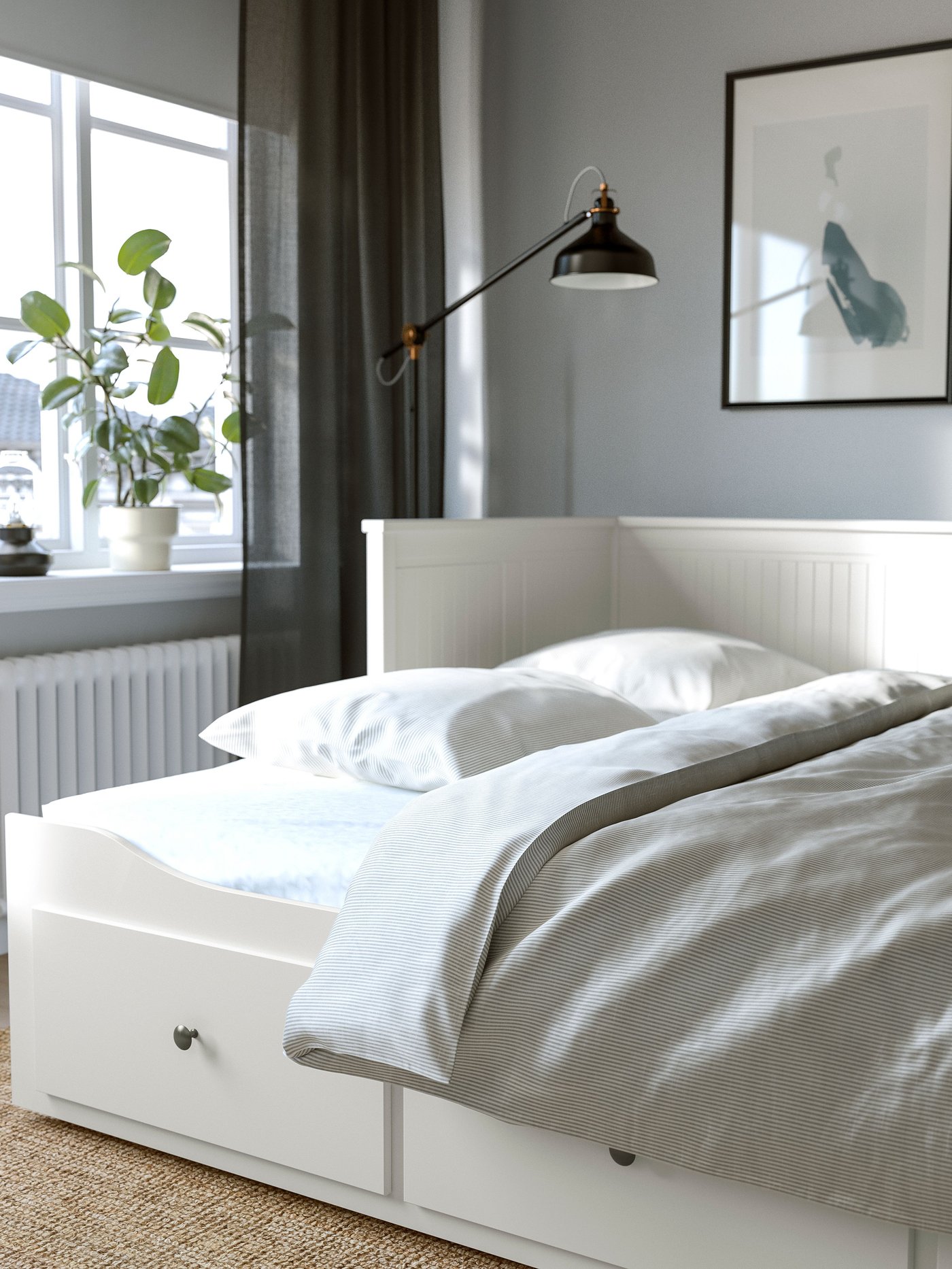Diván-cama HEMNES blanco con tres cajones en un dormitorio.